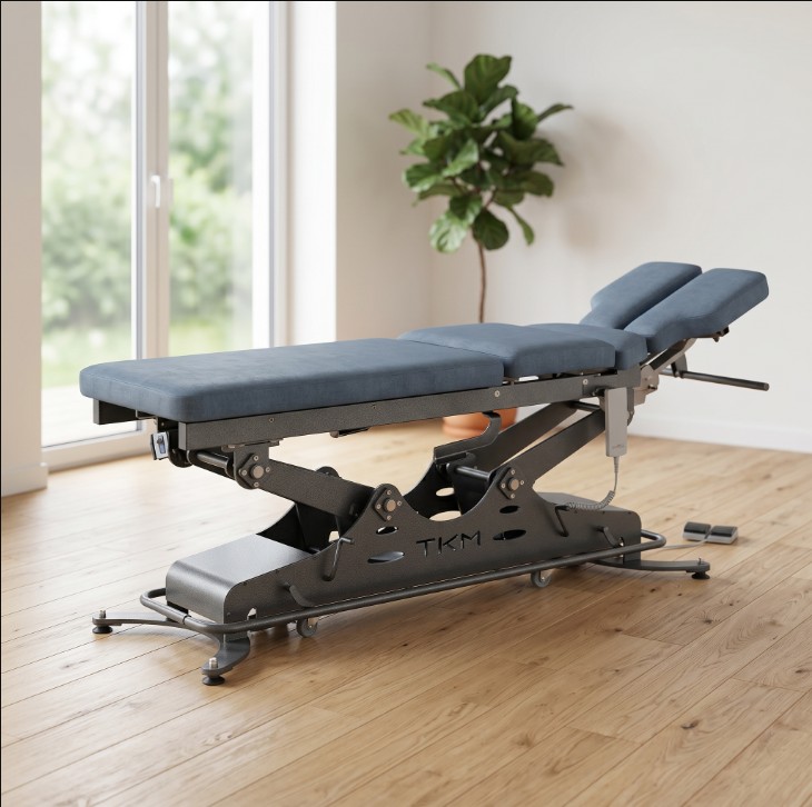 Table de soins electrique TKM, chassis anthracite et sellerie bleu sourd, dans un cabinet en lumiere naturelle